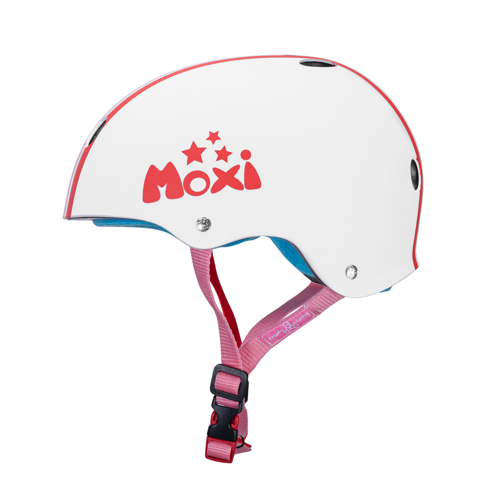 Side of Moxi Helmet named Stripey.  White helmet with Moxi logo on the side with stars above it. Straps of the helmet are pink.