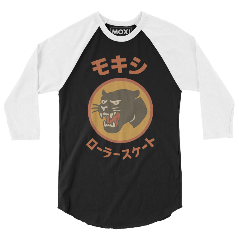 Black and white Moxi baseball tee with three-quarter raglan sleeves, featuring a bold retro-style panther logo in an orange circle and Japanese katakana text above and below the graphic translating to "Moxi Roller Skates."