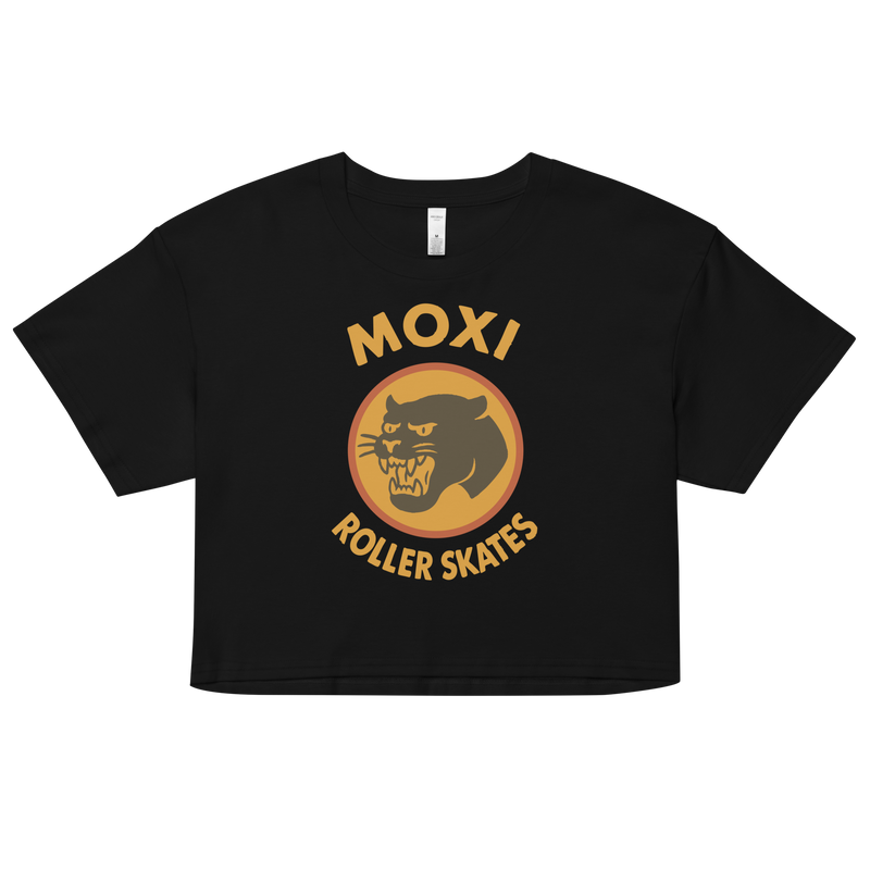 Black Moxi crop top with short sleeves, featuring a bold vintage-style graphic of a yellow and orange panther logo and “MOXI Roller Skates” text on the front.