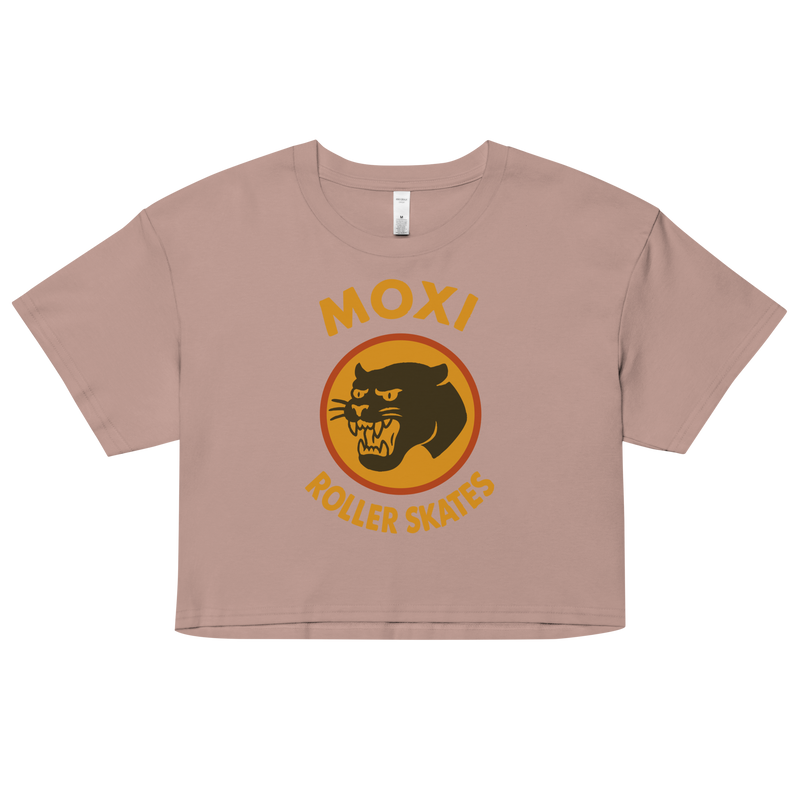 Blush Moxi crop top with short sleeves, featuring a bold vintage-style graphic of a yellow and orange panther logo and “MOXI Roller Skates” text on the front.