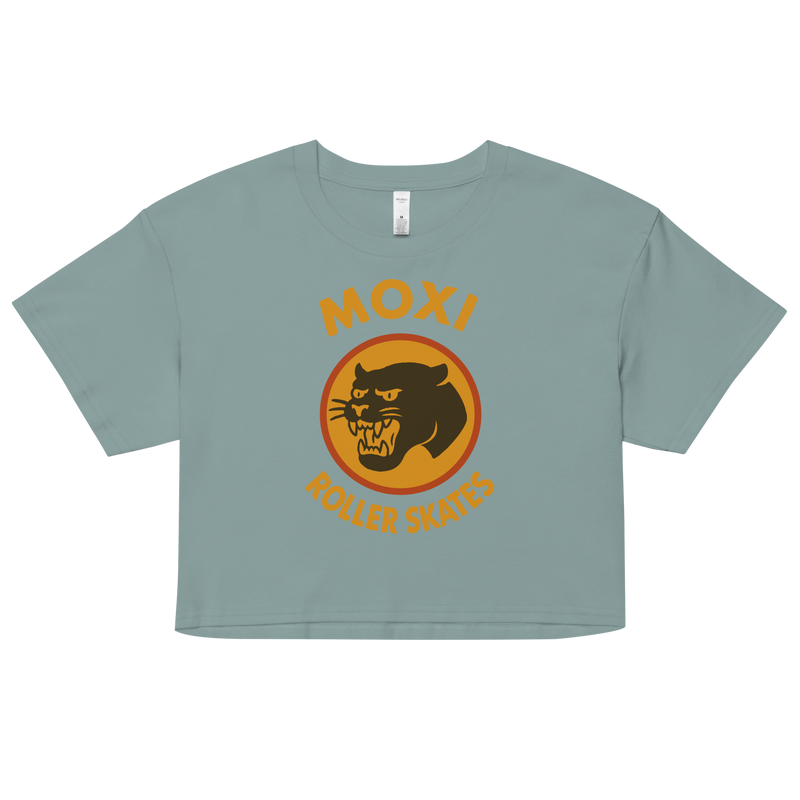 Green Moxi crop top with short sleeves, featuring a bold vintage-style graphic of a yellow and orange panther logo and “MOXI Roller Skates” text on the front.