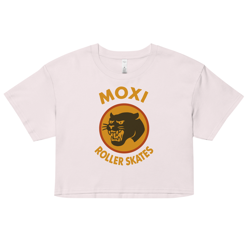 White Moxi crop top with short sleeves, featuring a bold vintage-style graphic of a yellow and orange panther logo and “MOXI Roller Skates” text on the front.
