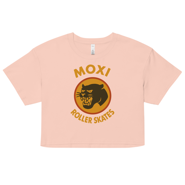 off white  Moxi crop top with short sleeves, featuring a bold vintage-style graphic of a yellow and orange panther logo and “MOXI Roller Skates” text on the front.